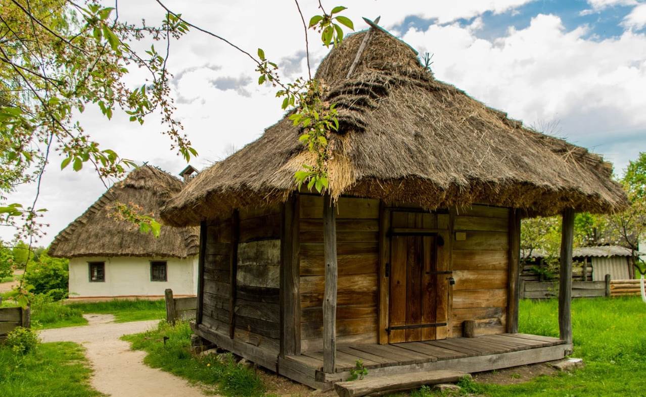 A traditional peasant hut with a wooden roof in the Pirogues Museum in Kyiv