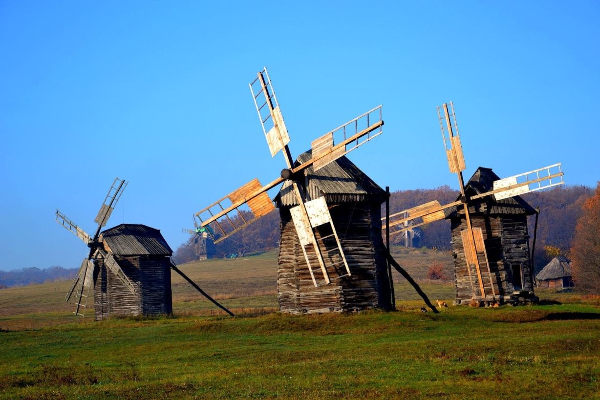 Ancient wooden windmills against a blue sky in the Pirogov Museum in Kyiv