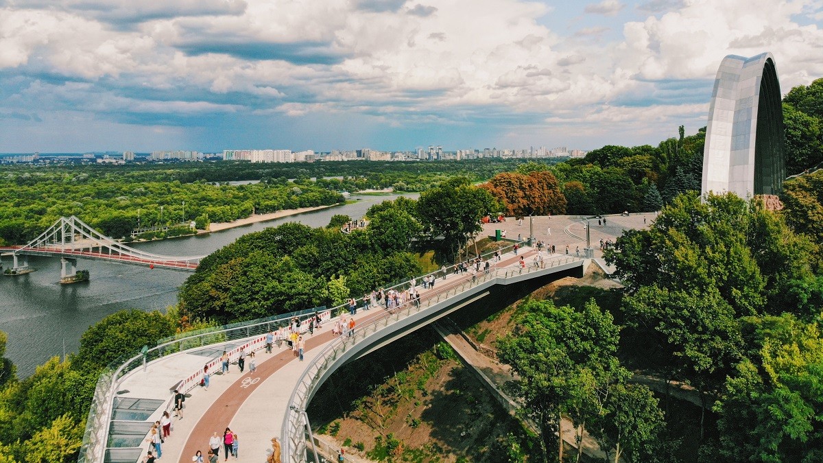 Glass Pedestrian Bridge in Kyiv - modern bridge with transparent glass floor offering panoramic views of the city and river.