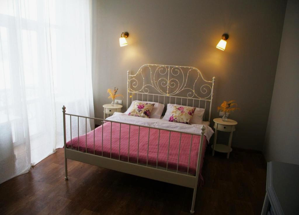 Double room with a decorative wrought iron bed at Kashtan Guest House in Kyiv