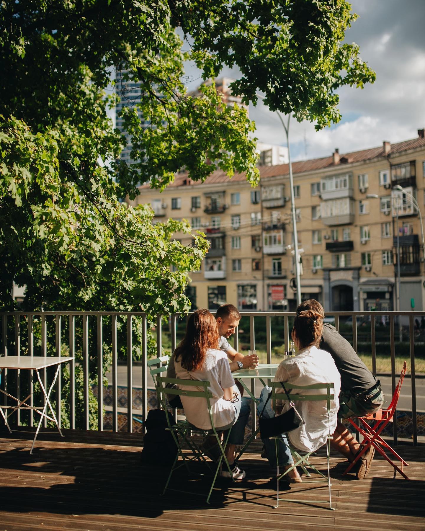 Octo Tower - outdoor terrace with people sitting at table under tree