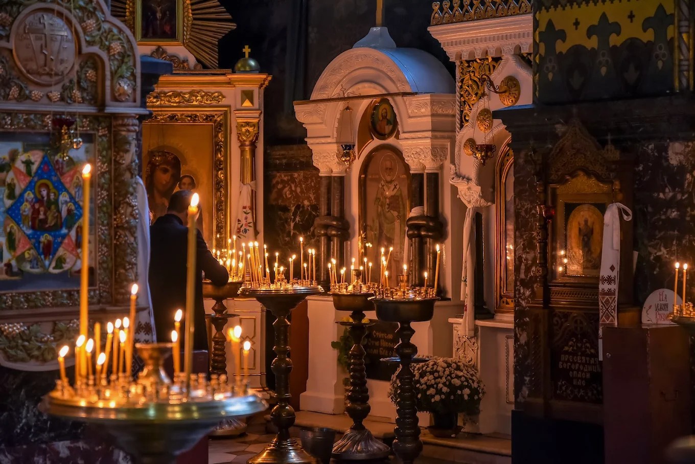 St. Volodymyr's Cathedral in Kyiv - burning wax candles on brass stand in front of icons