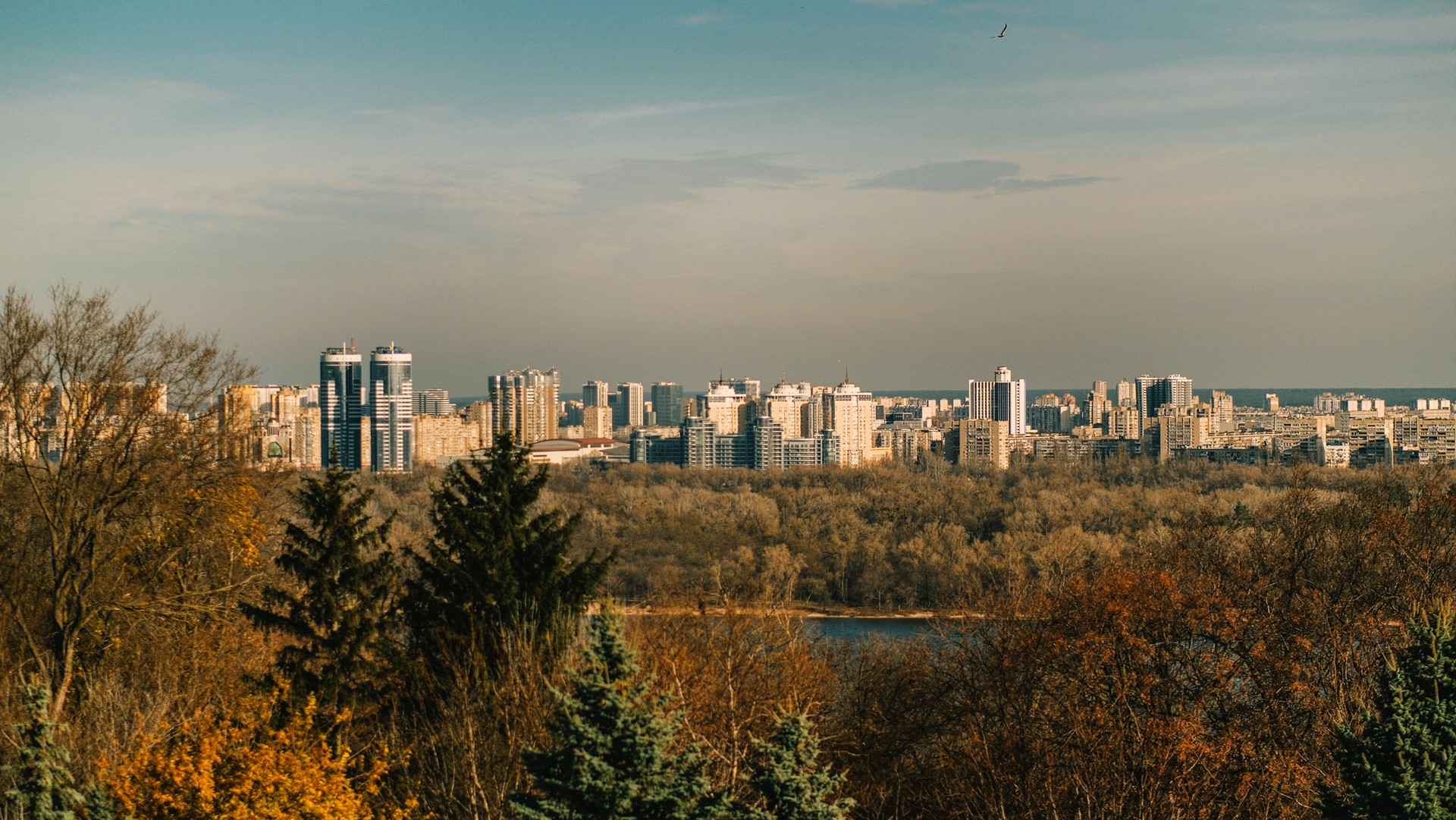 Park of Eternal Glory in Kyiv - Holodomor Memorial monument and golden domes of Lavra viewed from the park hills under a cloudy sky