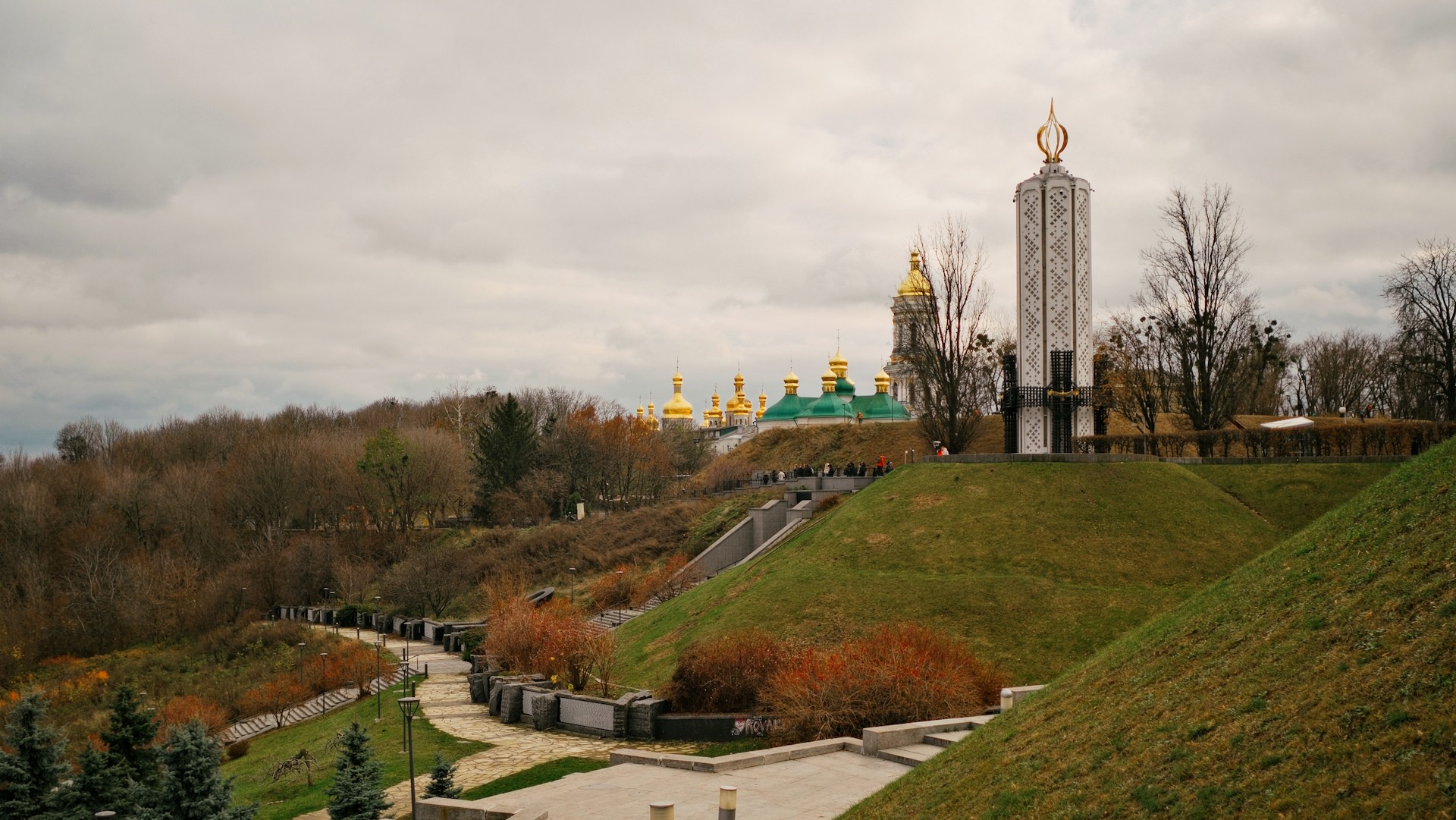 Park of Eternal Glory in Kyiv - people walking along the tree-lined alley towards the Obelisk