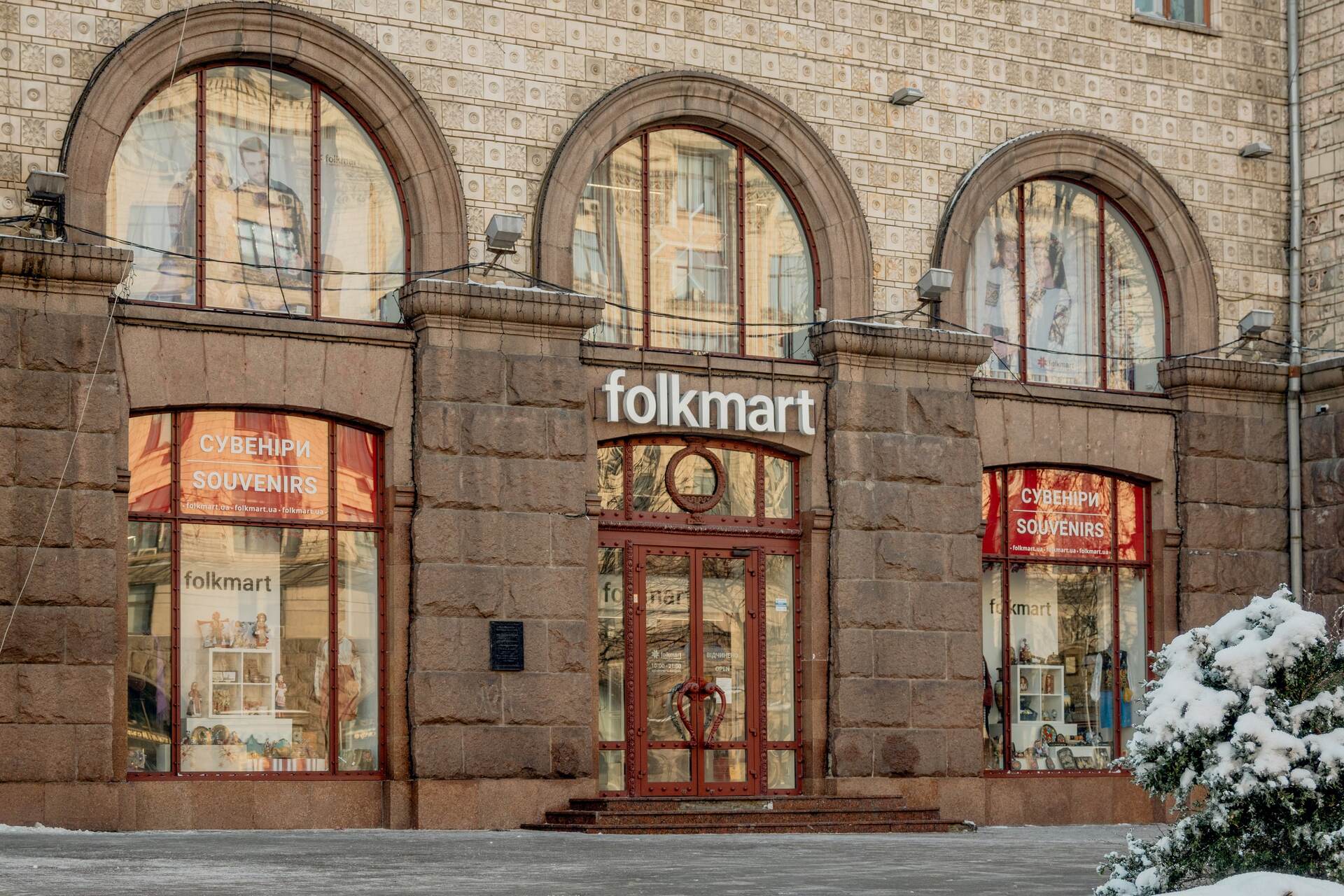 Stone facade with large arched windows of the Folkmart store in Kyiv