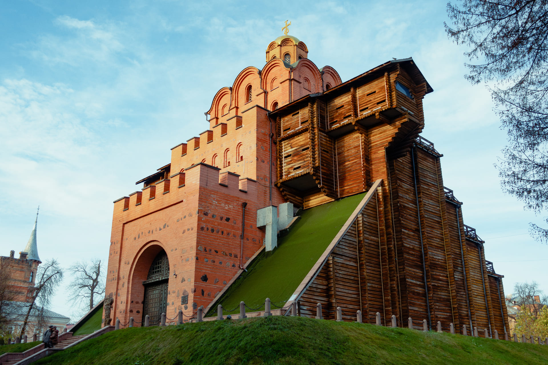 Golden Gate in Kyiv - reconstructed medieval gate with red brick walls, wooden fortifications and grassy slope