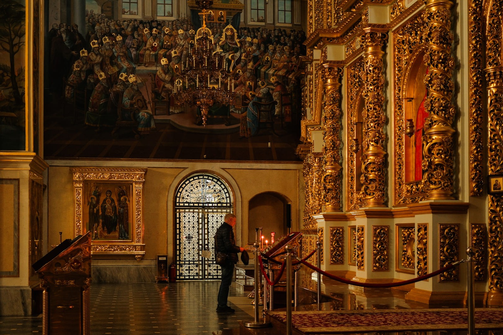 Kyiv Pechersk Lavra - gilded iconostasis inside the cathedral with religious paintings and candlelight