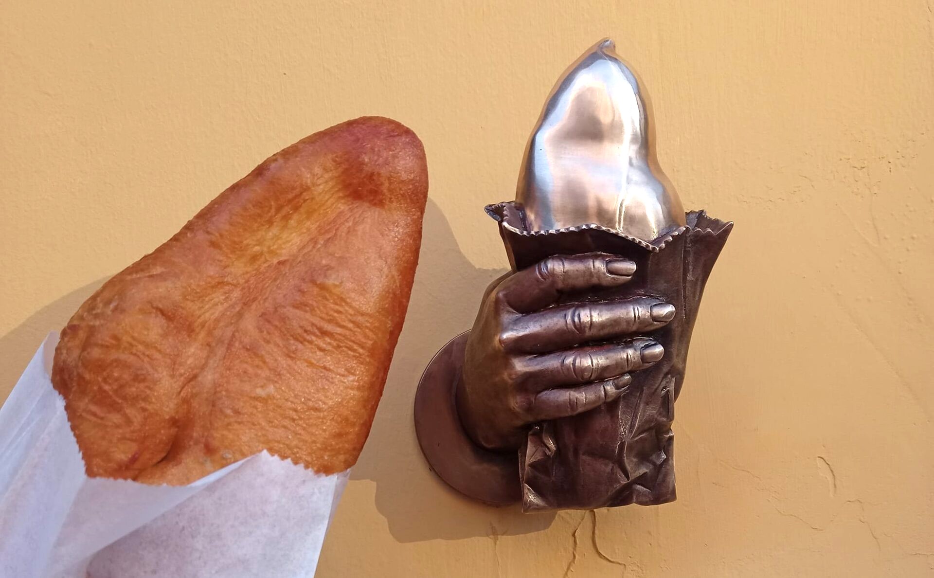 Kyivska Perepichka street food and a monument of a hand holding a Perepichka in Kyiv