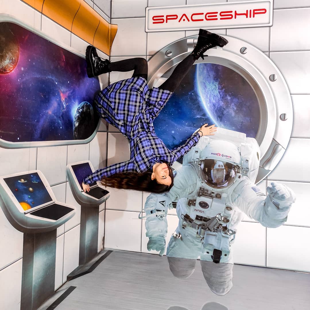 Perspective illusion of a woman at a photo museum