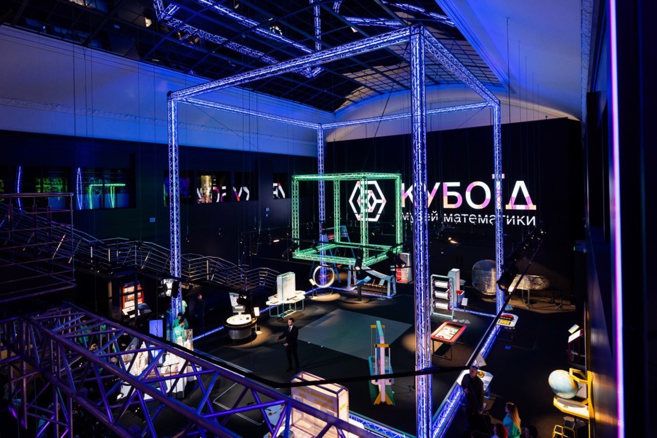 Museum of Mathematics Kuboid in Kyiv - grand museum atrium illuminated by blue neon structures featuring the glowing "Kuboid" logo and various science exhibits