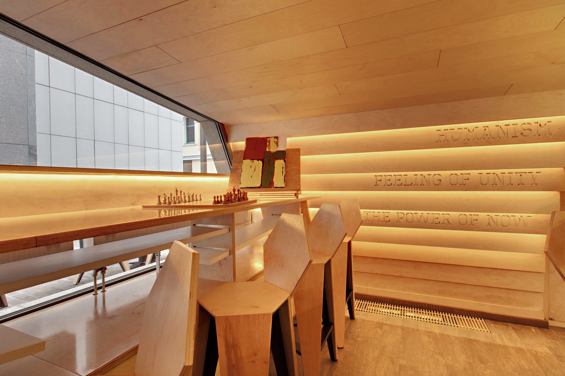 One Love Coffee in Kyiv - wooden interior corner with chess board by panoramic window