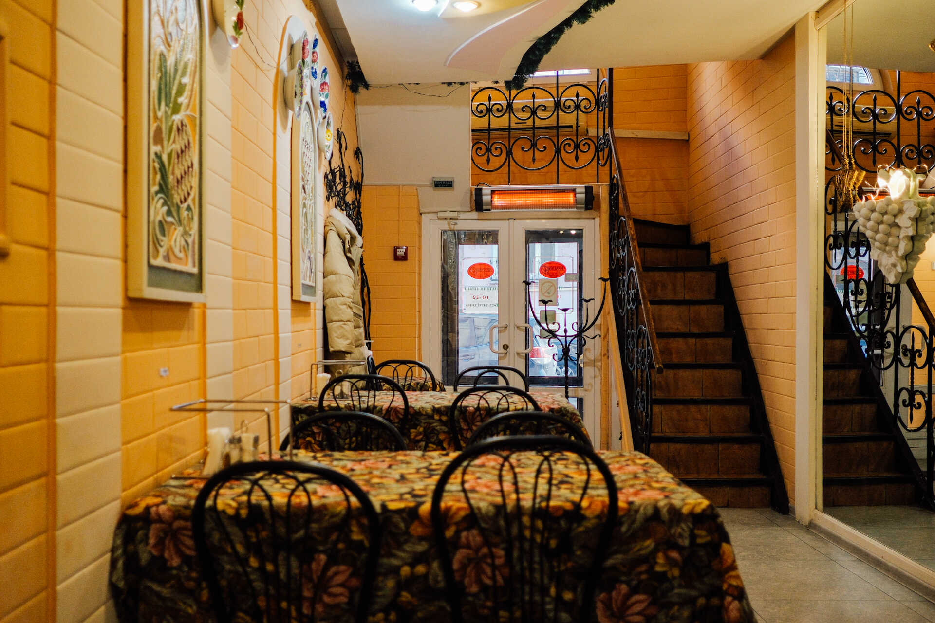 Cozy dining area at Vesuvio Pizza with floral tablecloths and a staircase