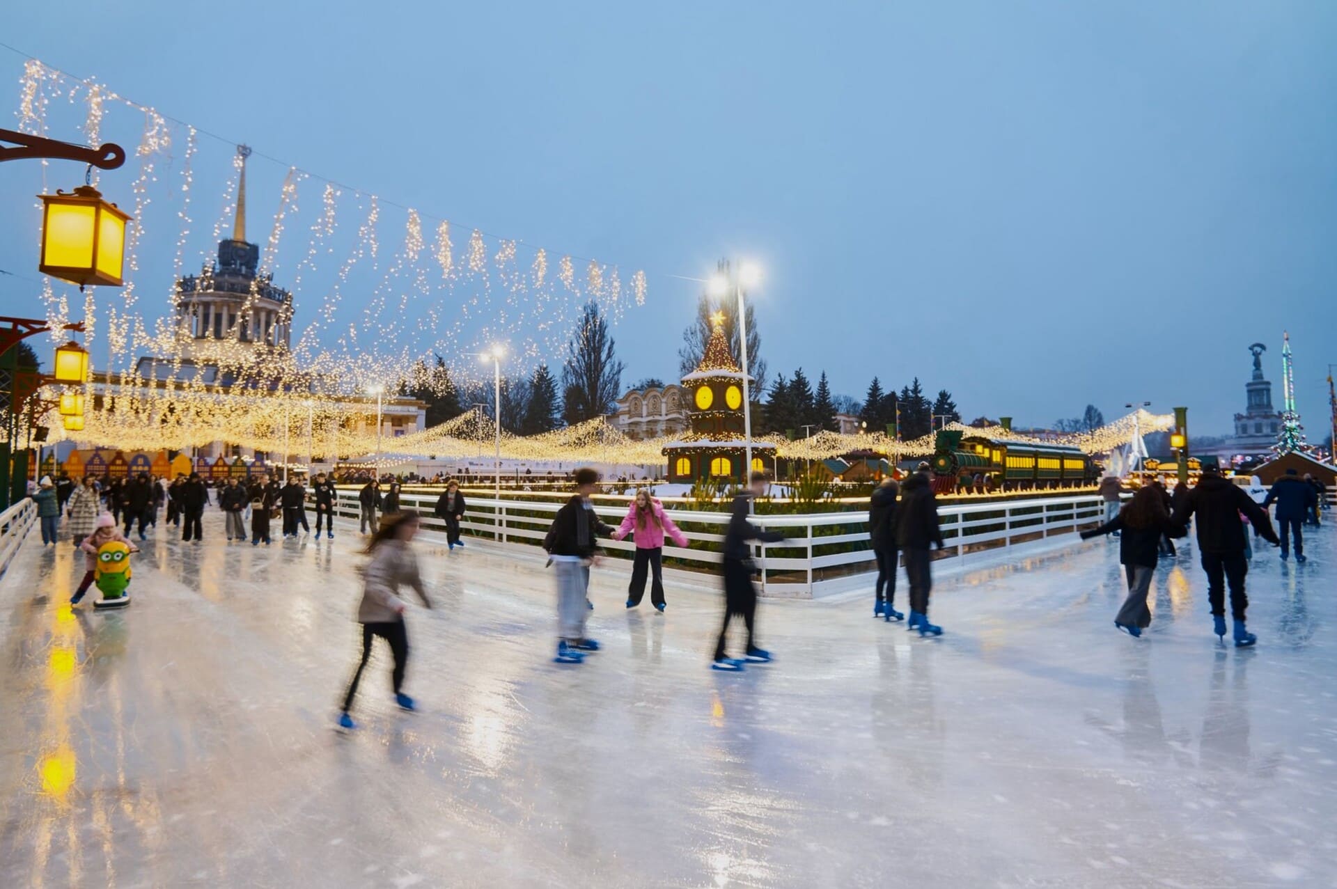 Outdoor ice rink with skaters and festive lights at VDNG in Kyiv