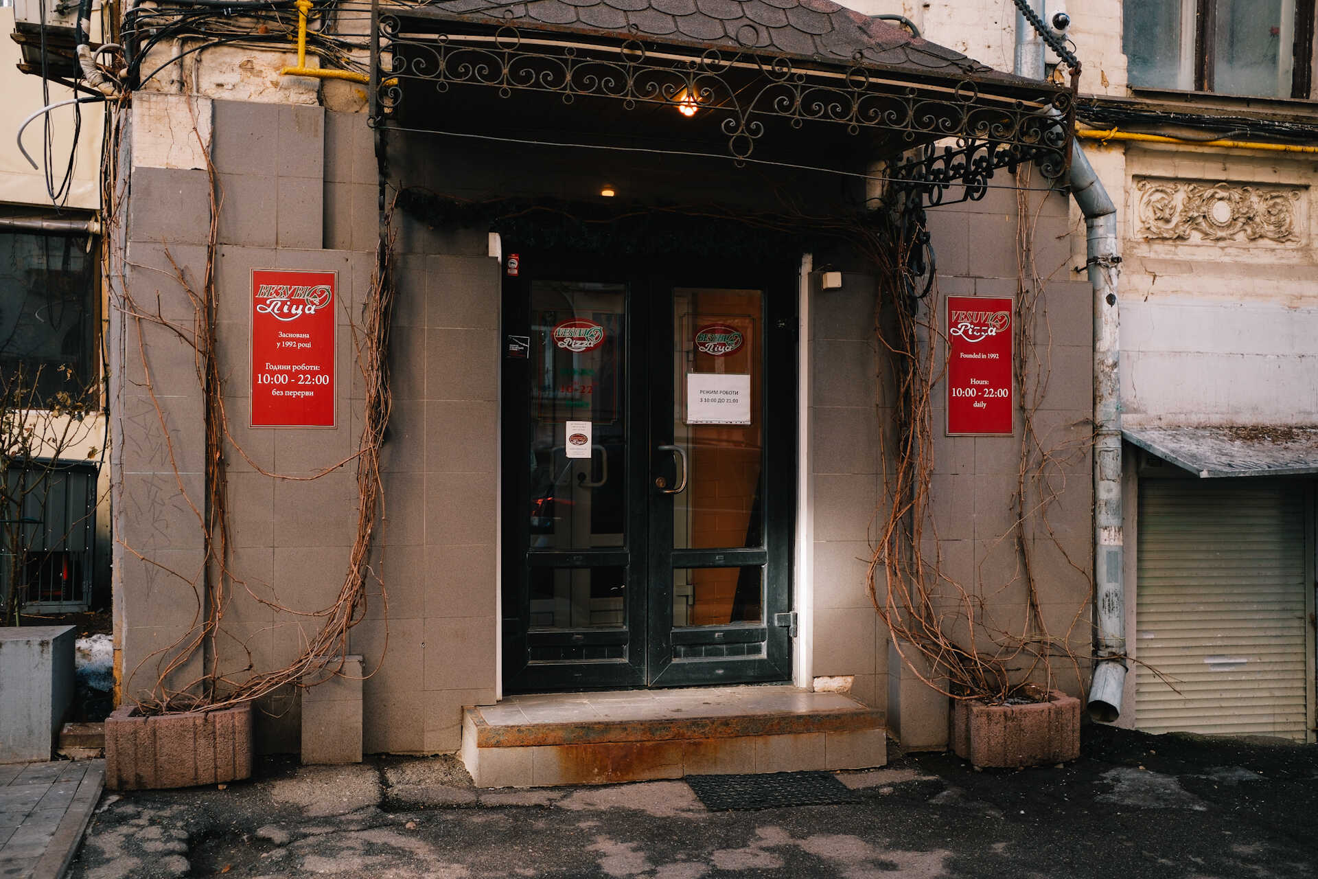 Entrance of Vesuvio Pizza with signage and decorative branches