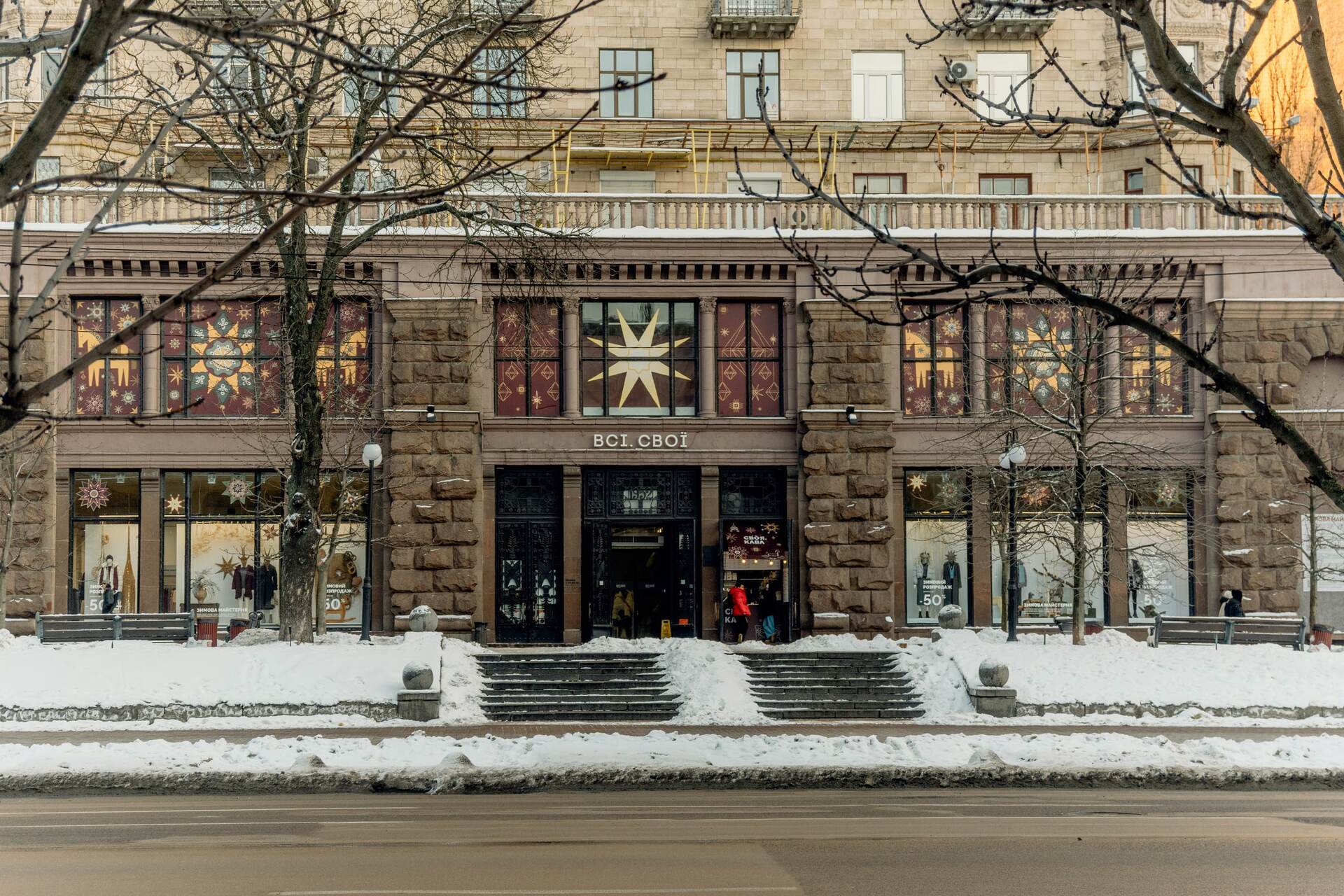 A street view of the Vsi Svoi store facade in winter in Kyiv