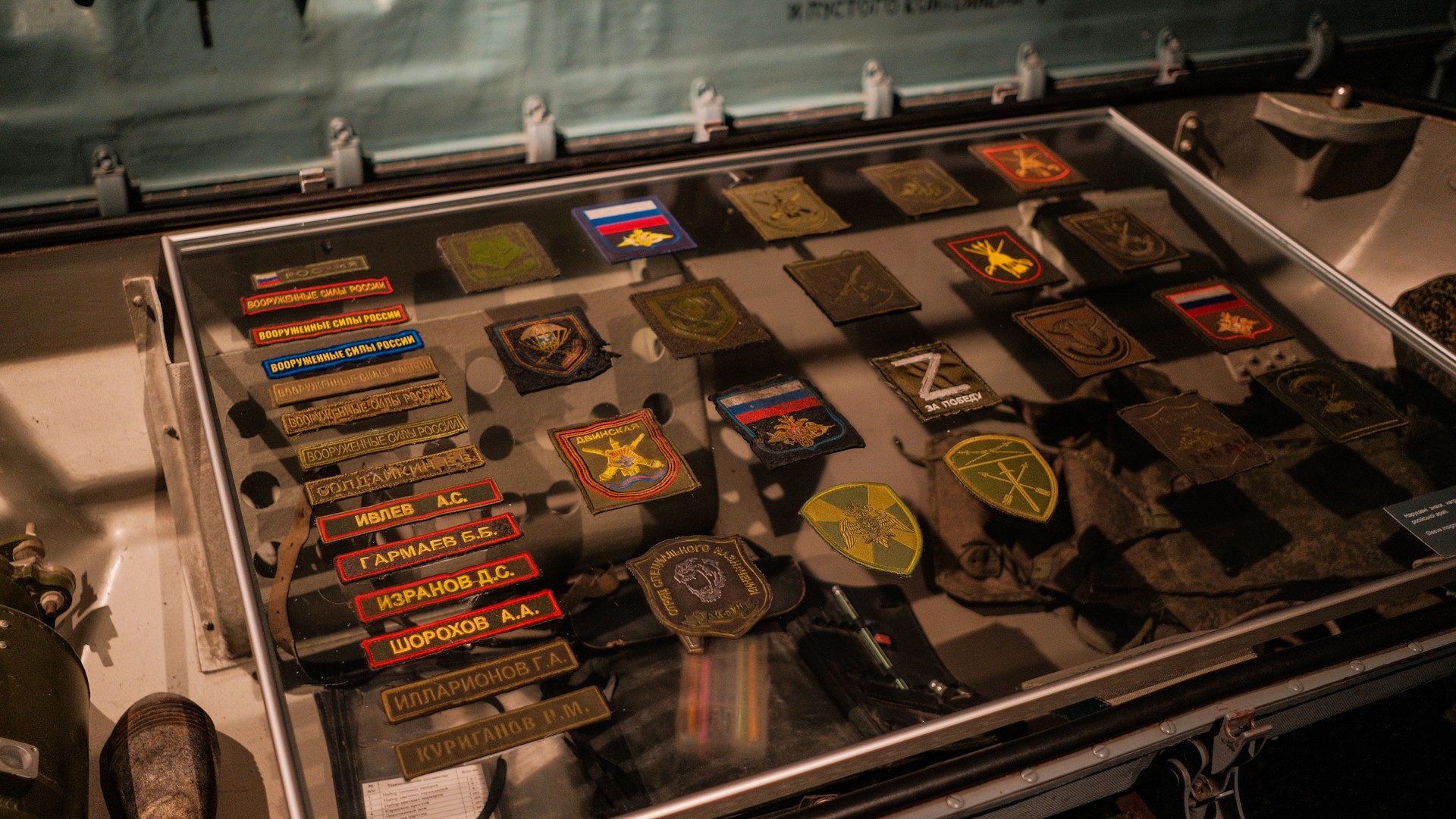 War Museum in Kyiv - glass display case filled with captured russian military patches, z symbols, and unit insignias