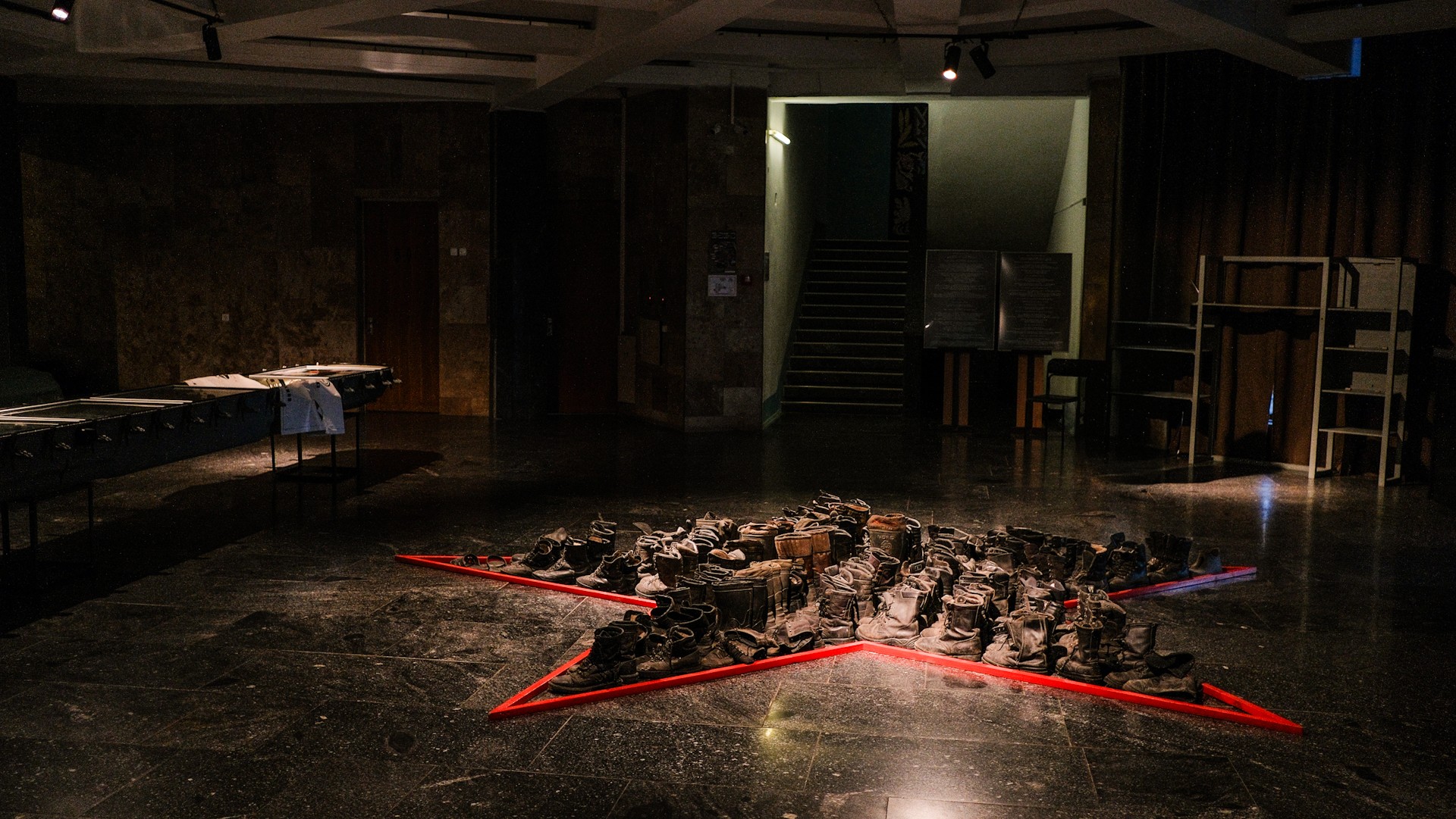War Museum in Kyiv - art installation featuring a red star outline on the floor filled with numerous pairs of burnt military boots