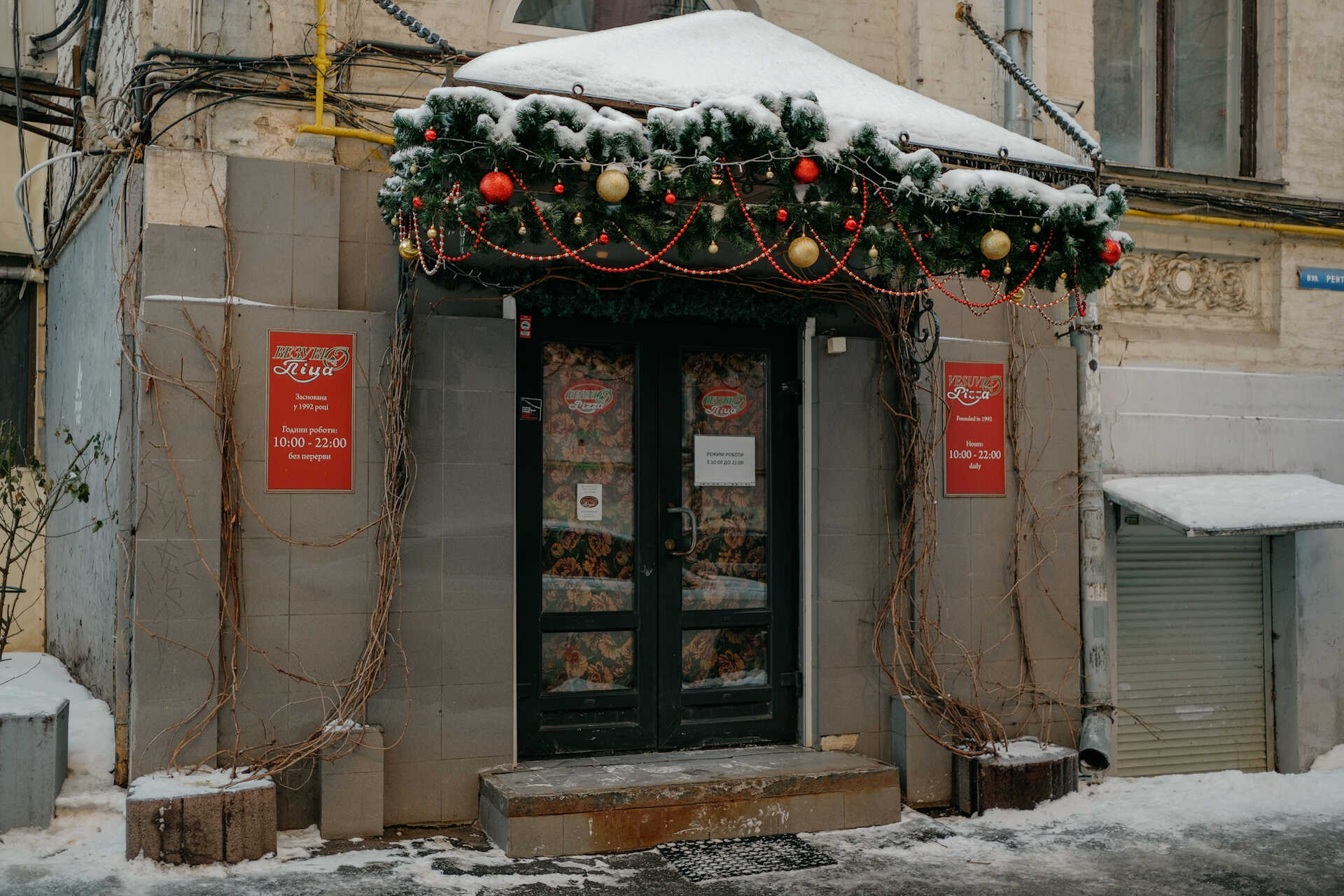 Front view of Vesuvio Pizza entrance with Christmas greenery in Kyiv