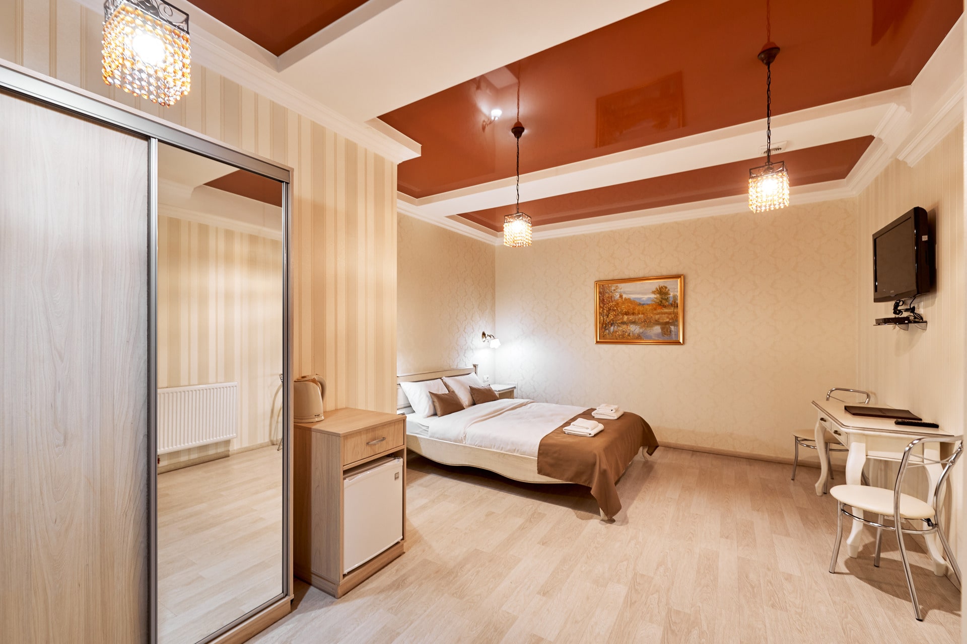 Cozy bedroom in Hotel Classic with a bed, mirror, and small dining set