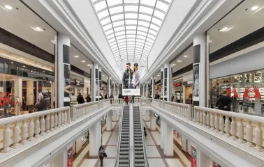 Gallery of shops in the Globus shopping center with an escalator and a light roof