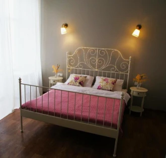 Double room with a decorative wrought iron bed at Kashtan Guest House in Kyiv