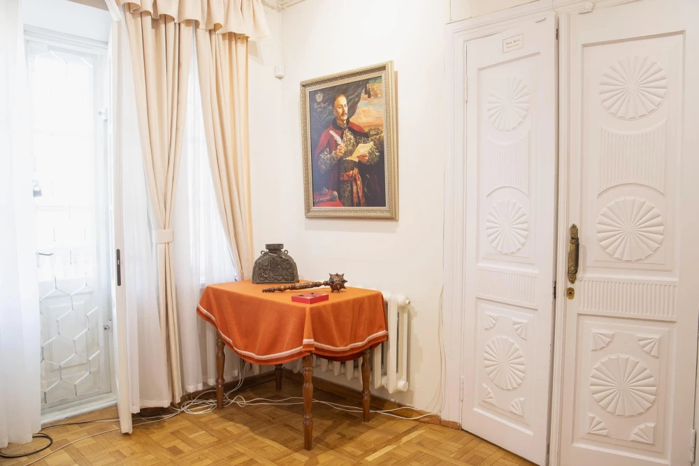Muzei Hetmanstva in Kyiv - historic interior corner featuring a traditional Cossack mace resting on a table beneath a painted portrait of a Hetman