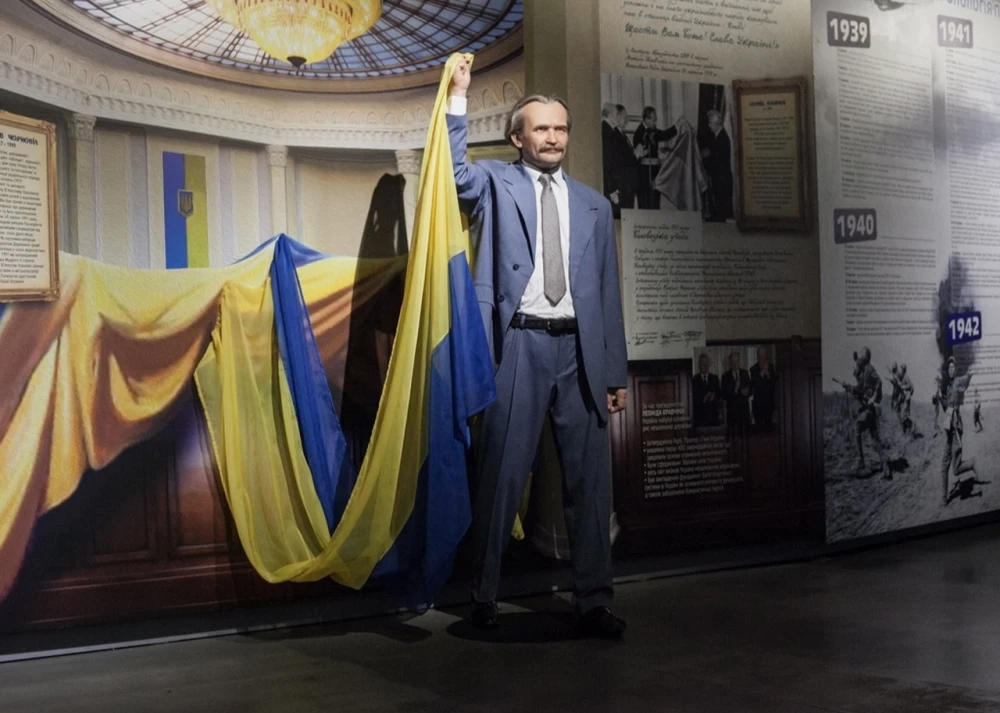 Muzei Stanovlennia Ukrainskoi Natsii in Kyiv - wax figure of Viacheslav Chornovil in a grey suit enthusiastically raising the Ukrainian flag