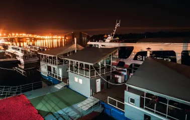 Poshtova Square in Kyiv - night view of the river pier with docked ships and lights reflecting on water