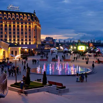 Poshtova Square in Kyiv - evening view with illuminated fountains and walking people