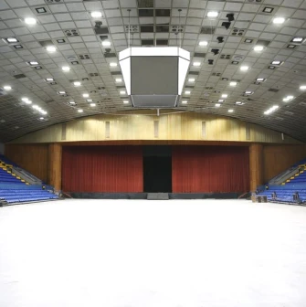 Palats Sportu in Kyiv - vast empty white arena floor leading to a stage concealed by heavy red curtains