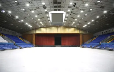 Palats Sportu in Kyiv - vast empty white arena floor leading to a stage concealed by heavy red curtains