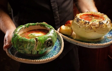 Restaurant Kanapa - waiter holding two artistic dishes with borscht
