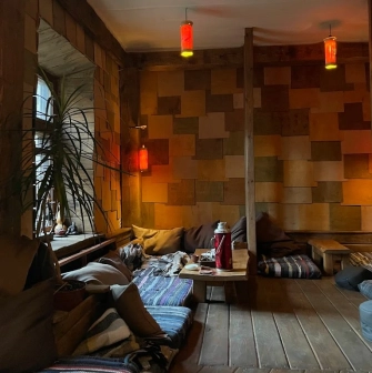 Chaguan in Kyiv - low seating area with floor cushions and hanging red lanterns