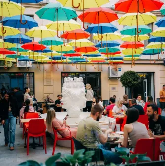 Restaurant Tisto, Syr i Titka Bella - courtyard seating under colorful suspended umbrellas