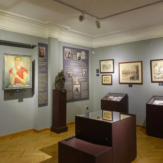 Muzei Ukrainskoi Diaspory in Kyiv - detailed view of the exhibition featuring a vibrant portrait of a woman and bronze sculptures in a well-lit gallery space