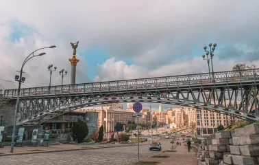 Thousand Years Bridge in Kyiv- bridge arching over the street with the monument behind