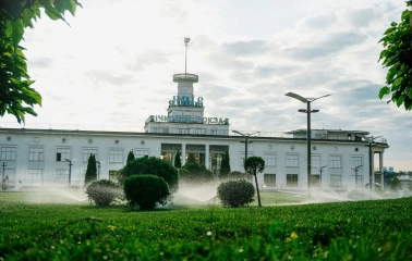 Poshtova Square in Kyiv - river station building with a tower and Kyiv sign behind green lawn
