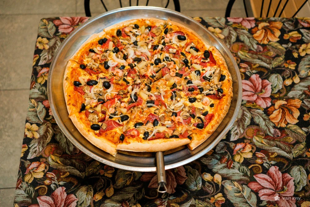 Pizza with olives, mushrooms, and meat ingredients at Vezuvio pizza