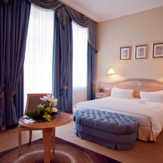 Classic room at the Opera Hotel in Kyiv with a large bed and blue curtains