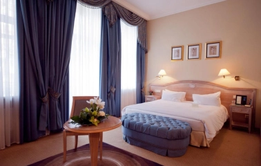 Classic room at the Opera Hotel in Kyiv with a large bed and blue curtains