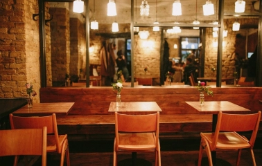Bar Restaurant Kosatka - indoor seating area with wooden tables booth seating and exposed brick