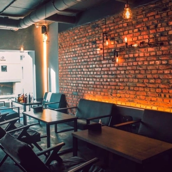 Vugol na Arsenalnii - lounge area with brick wall and sofas