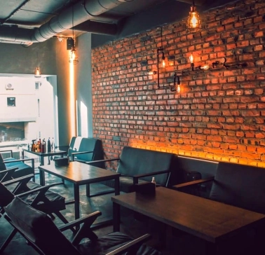 Vugol na Arsenalnii - lounge area with brick wall and sofas