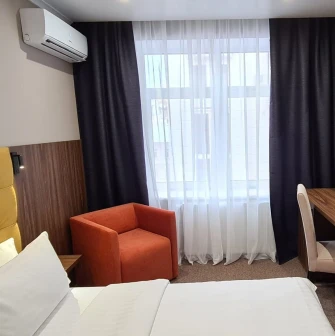 Hotel room at Bontiak Hotel with a desk and armchair