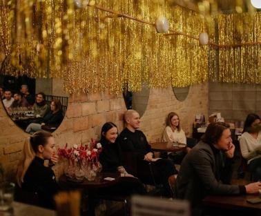 Restaurant Zigzag - interior with tinsel decorations a brick wall and seated guests