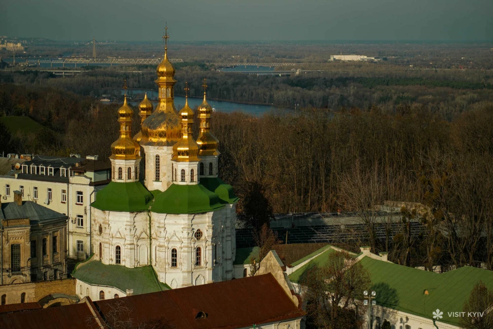 Вид згори на золоті бані Трапезної церкви Києво-Печерської лаври та річку Дніпро в Києві