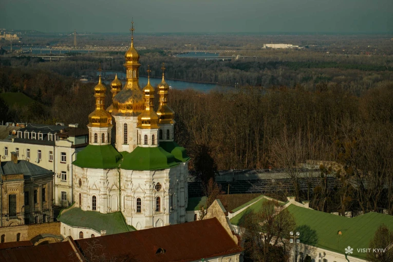 Top view of the golden domes of the Refectory Church of Kyiv Pechersk Lavra and the Dnipro River in Kyiv