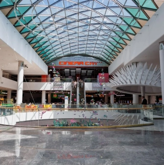 Ocean Plaza in Kyiv - grand central atrium under a curved glass dome featuring escalators leading to the cinema and a futuristic white spiky structure