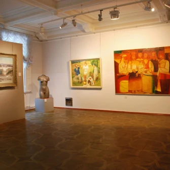 Kyivska Kartynna Halereia in Kyiv - spacious exhibition room with paintings, a torso sculpture and patterned parquet