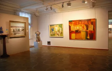 Kyivska Kartynna Halereia in Kyiv - spacious exhibition room with paintings, a torso sculpture and patterned parquet